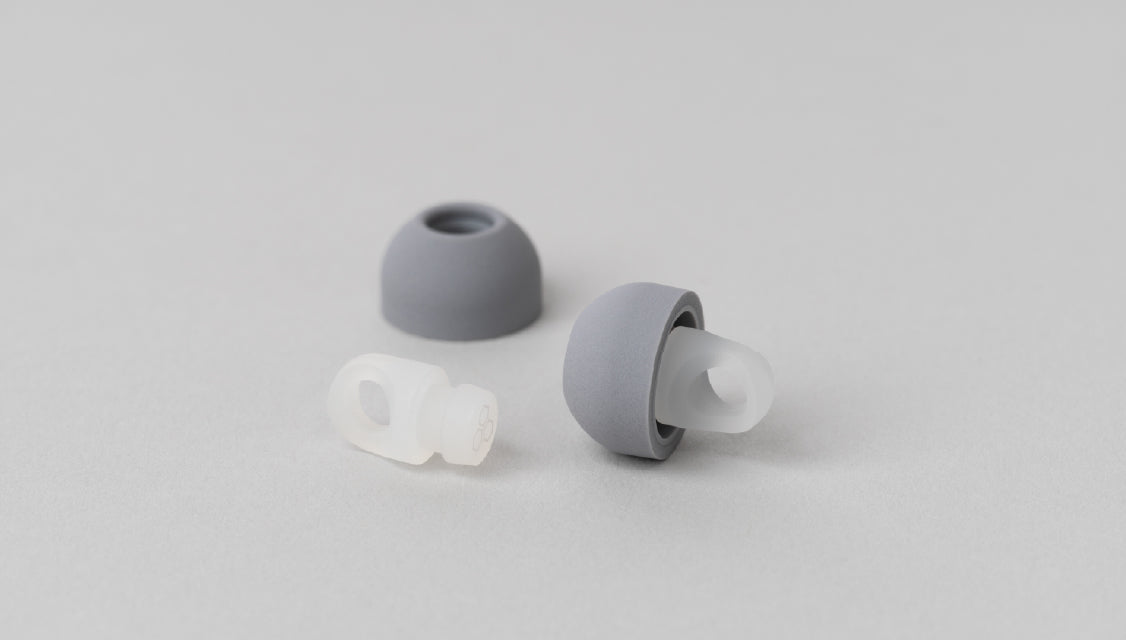 final YOKONE ultra-small side-sleeping earplugs positioned next to their compact grey premium silicone storage case